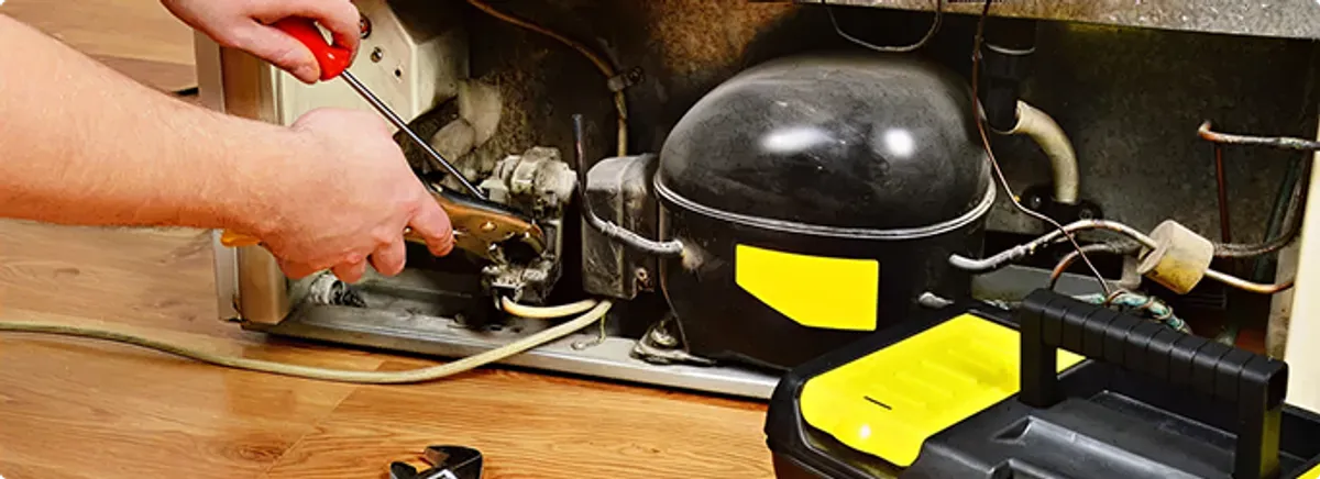 Refrigerator repair technician fixing the compressor and wiring in Dania, FL