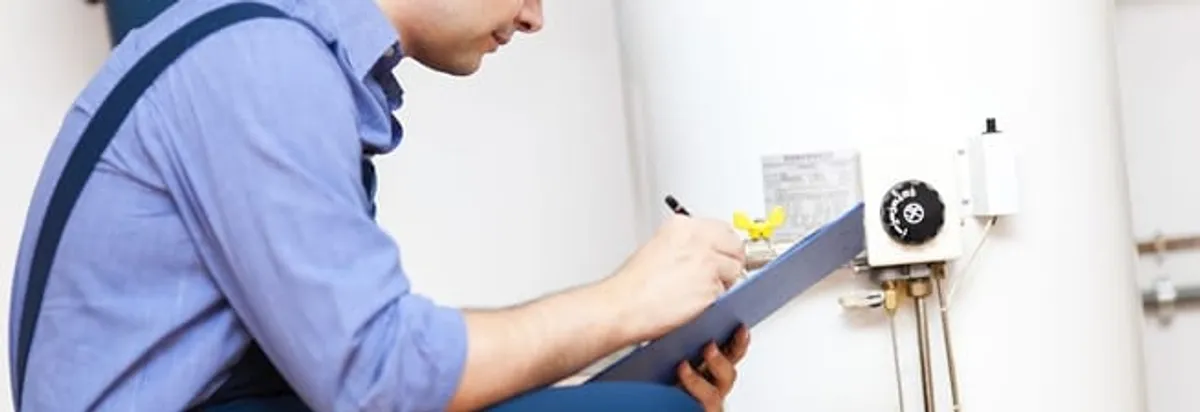 Water heater repair technician inspecting the unit and recording service notes in Hollywood, FL